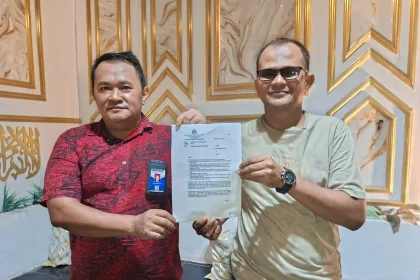 Tanjung Buser (kanan) didampingi kuasa hukumnya, Ilfan Rambe (kiri), menunjukkan surat SP2Lid saat menggelar konferensi pers di kediamannya, Karimun, Jumat (17/4/2026) | Foto: Ami
